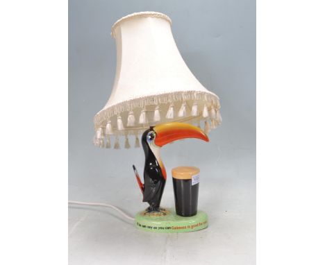 A vintage retro ceramic Carlton Ware Guinness advertising lamp having a green base with classic toucan and Guinness pint, rea