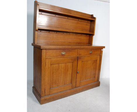 An early 20th century circa 1920’s - 1930’s oak dresser. The dresser having and open detachable shelve unit atop over a cupbo