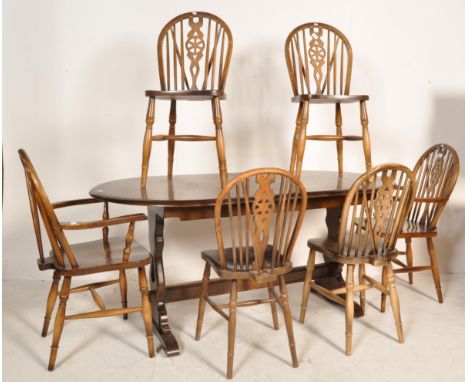 A retro vintage late 20th century Ercol style beech and elm dining table and chairs. The table has chamfered edges raised on 