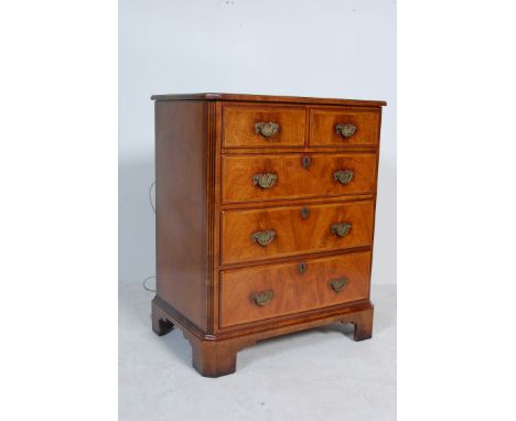 A contemporary Queen Anne style walnut chest of drawers / hi fi cabinet having two faux drawers to the top opening to reveal 