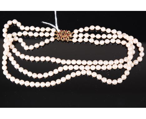 A cultured pearl triple string choker, having 9ct gold garnet set clasp