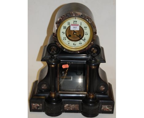 A late Victorian black slate marble inset mantel clock of architectural form having an enamelled dial with Arabic numerals an