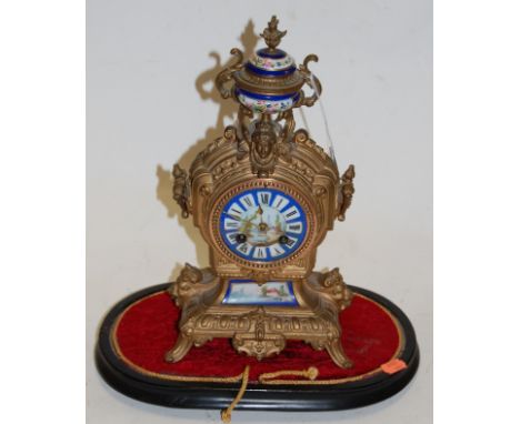 A late 19th century French gilt metal mantel clock having a porcelain inset dial with Roman numerals and eight day movement, 