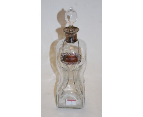 A Victorian glass decanter, of hourglass form, with white metal collar and whisky label 