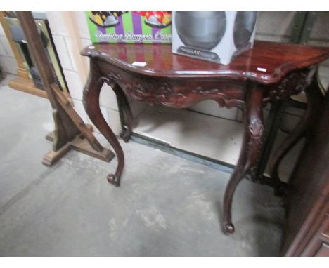 A carved mahogany console table.