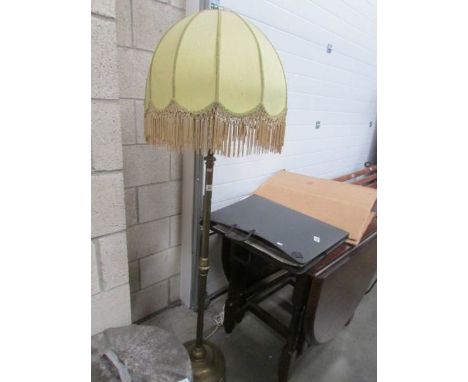 A brass adjustable standard lamp with shade.
