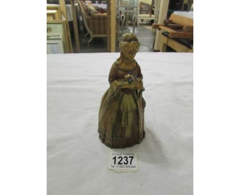 An Austrian cold painted touch tip lighter of a lady in a crinoline dress holding a dog.