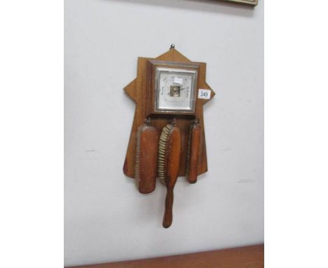 A barometer/brush set on oak back.