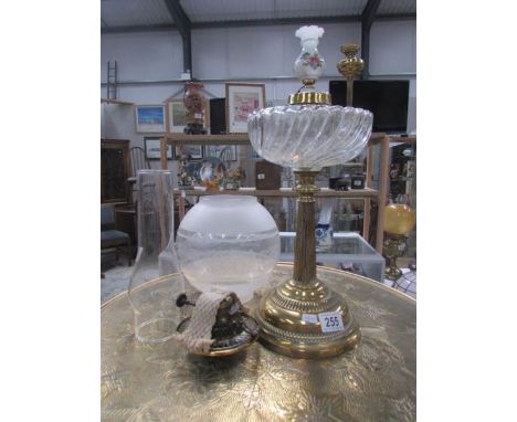 An oil lamp with brass base, glass font, burner, etched shade and chimney.