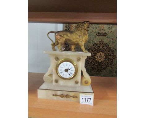 A French alabaster mantle clock surmounted lion.