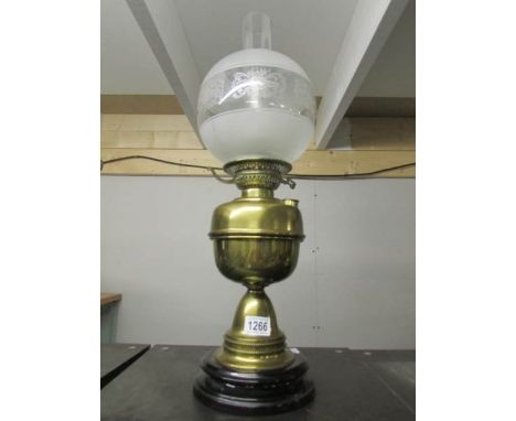 A brass oil lamp with pot base, drop in font and complete with shade and chimney.