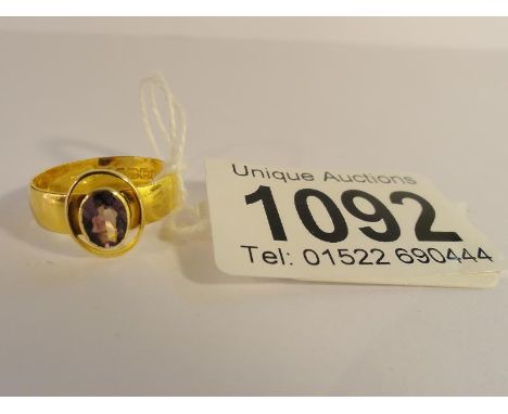 A 22ct gold amethyst set band ring with oval cut amethyst approximately 0.65cts, hall marked Birmingham 1918, size N.