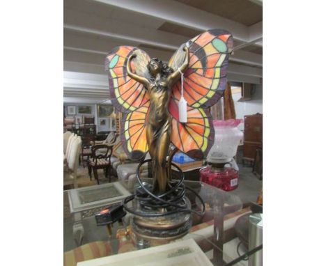 An art nouveau style figurine table lamp with Tiffany style leaded glass wings.