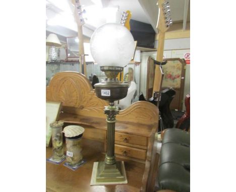 A brass Corinthian column oil lamp complete with shade and chimney.