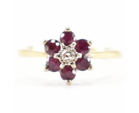 WITHDRAWN An 18ct gold diamond and ruby floral cluster ring. The ring being set with a central round cut diamond to the centr