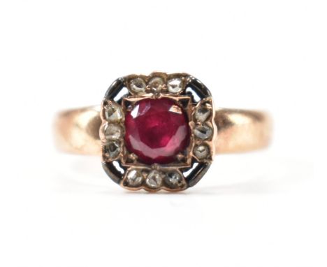 A 9ct gold ruby and diamond cluster ring. The ring with a centre round cut ruby surrounded by 12 rose cut diamonds being set 