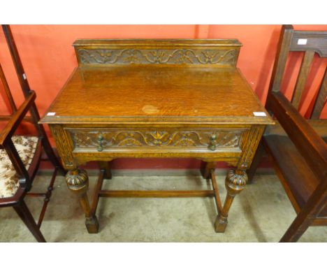 A 17th Century style carved oak single drawer side table