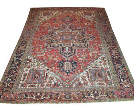 ANTIQUE HERIZ CARPET, 375cm x 272cm, of sapphire central medallion on cerise field within ivory spandrels, multiple bands and