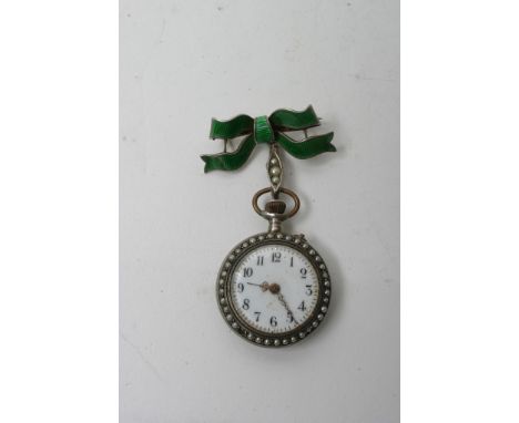 A lady's white metal fob watch with enamel decorated back on green bow shaped bar