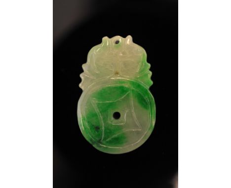 A green jade pendant in the form of a bi-disc surmounted with stylized fish