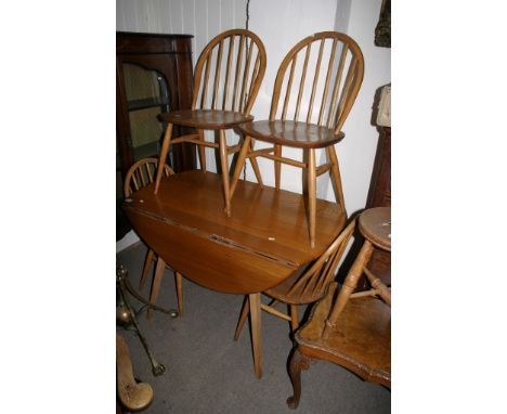 A light wood Ercol table and four chairs.