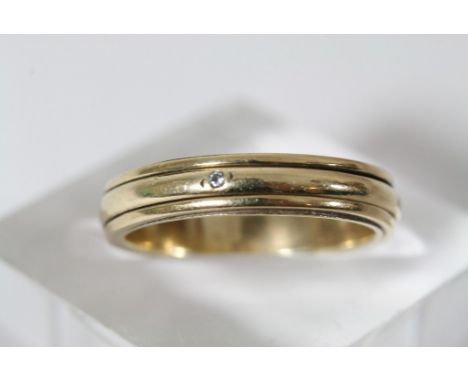 A 9ct gold wedding ring inset with small CZ