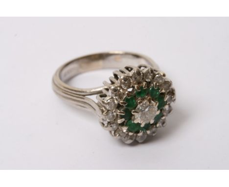 A 18ct white gold diamond and emerald set cluster ring