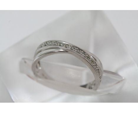 A silver crossover ring set with chip stone diamonds