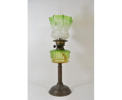 A Victorian oil lamp with green glass shade