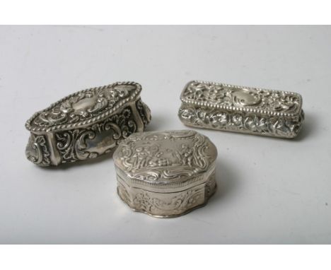 Three silver trinket boxes with scrolled and figural decoration, two bearing Chester hallmarks