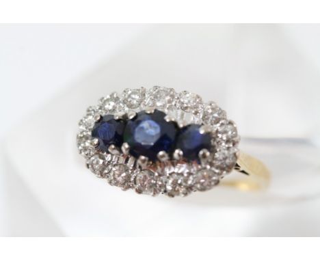 A 18ct yellow gold blue sapphire and diamond cluster ring, the centre with three graduating sapphires