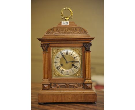 An Edwardian walnut mantel clock, the silver chapter ring with Roman numerals the cased carved with art nouveau influence
