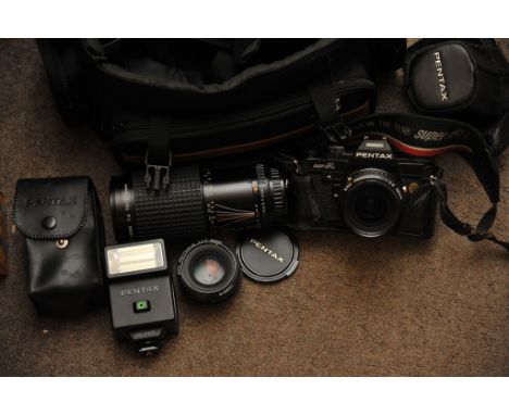 A cased Pentax camera and accessories including a 210mm lens