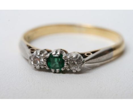 An 18ct gold ring set with diamonds and a single emerald