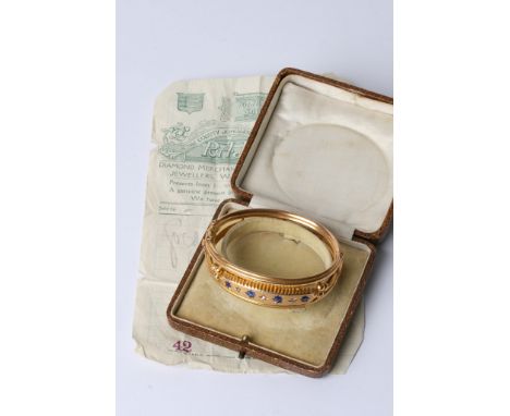 A gold bangle with sapphires and diamonds