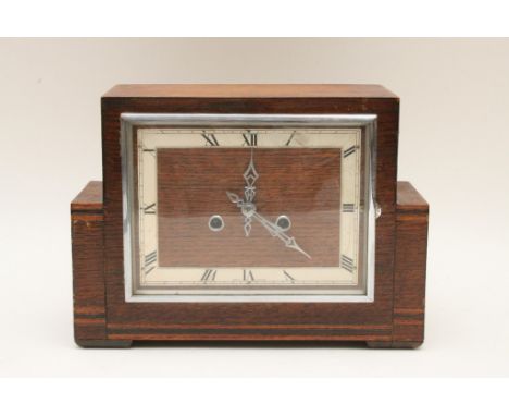 An Art-Deco, oak and chrome mantle clock of stylish design with inlaid banded decoration, the dial with chrome hands and deta