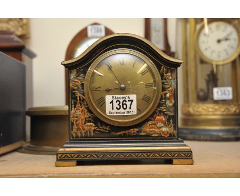 An Oriental lacquered mantle clock decorated with typical Oriental scenes.