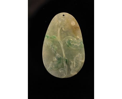 A jade oval pendant carved with stylized fish
