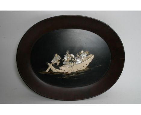 An oval Japanese lacquer plaque decorated with figures in a boat. Measures 52cm