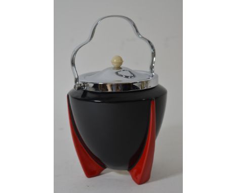 An Art Deco Wilkinson 'Yoo Hoo' pattern biscuit barrel having black body on red fin shaped feet with chrome lid and handle, d