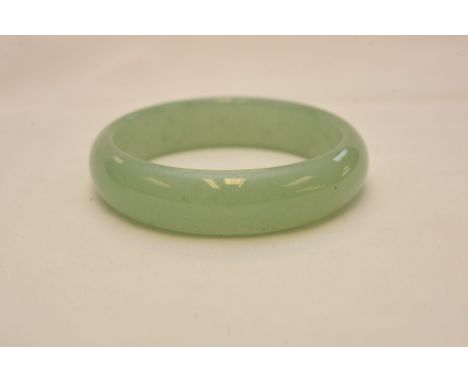 A pale green jadite bangle, 8cm approx