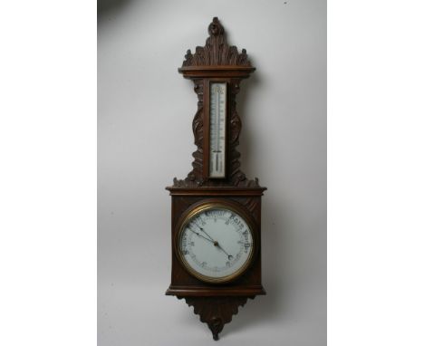 A carved oak aneroid barometer with thermometer box.