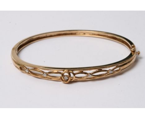 A 9ct gold bangle set with five small diamonds