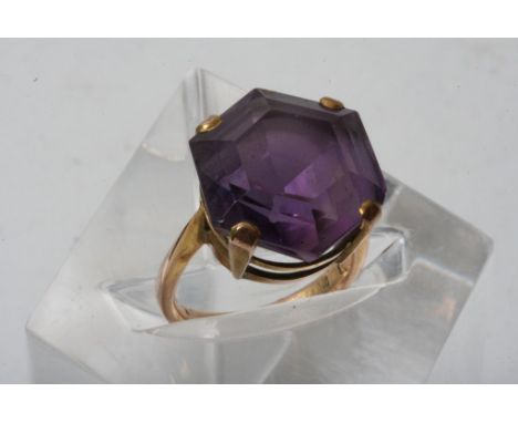 A 9ct gold ring set with a large hexagon shaped amethyst coloured stone