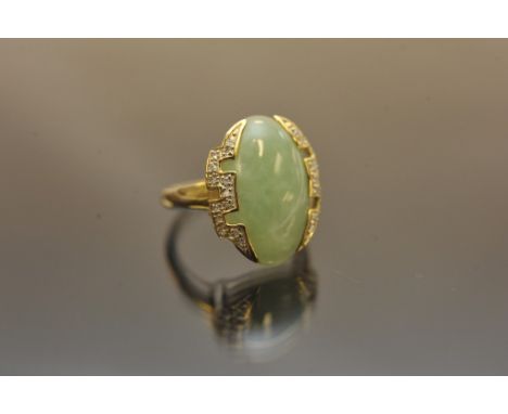 A gold tone ladies ring, the centre with a jadite oval stone