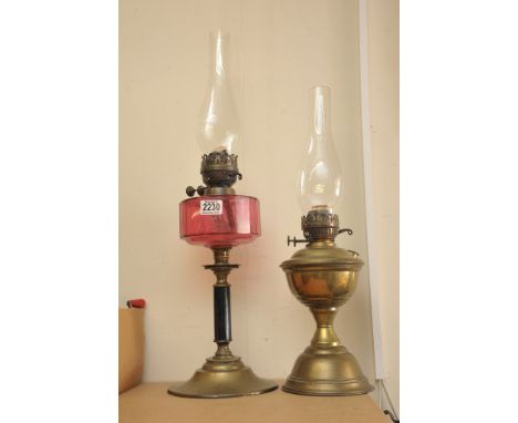  A Victorian cranberry glass oil lamp and one other brass oil lamp (2)