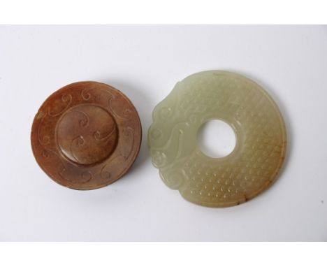 A carved jade disc and one other smaller.