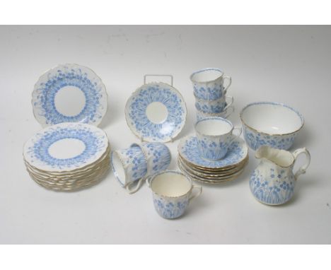 A Foley part tea service decorated with blue flowers and foliage on a white ground.