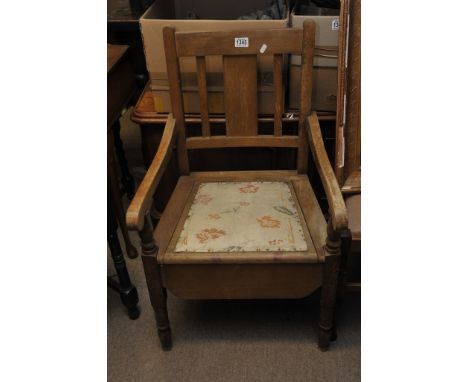 An antique commode fitted with china insert.