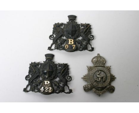 Two numbered City of London helmet plates, both minus one lug plus a Kings Crown Isle of Man plate